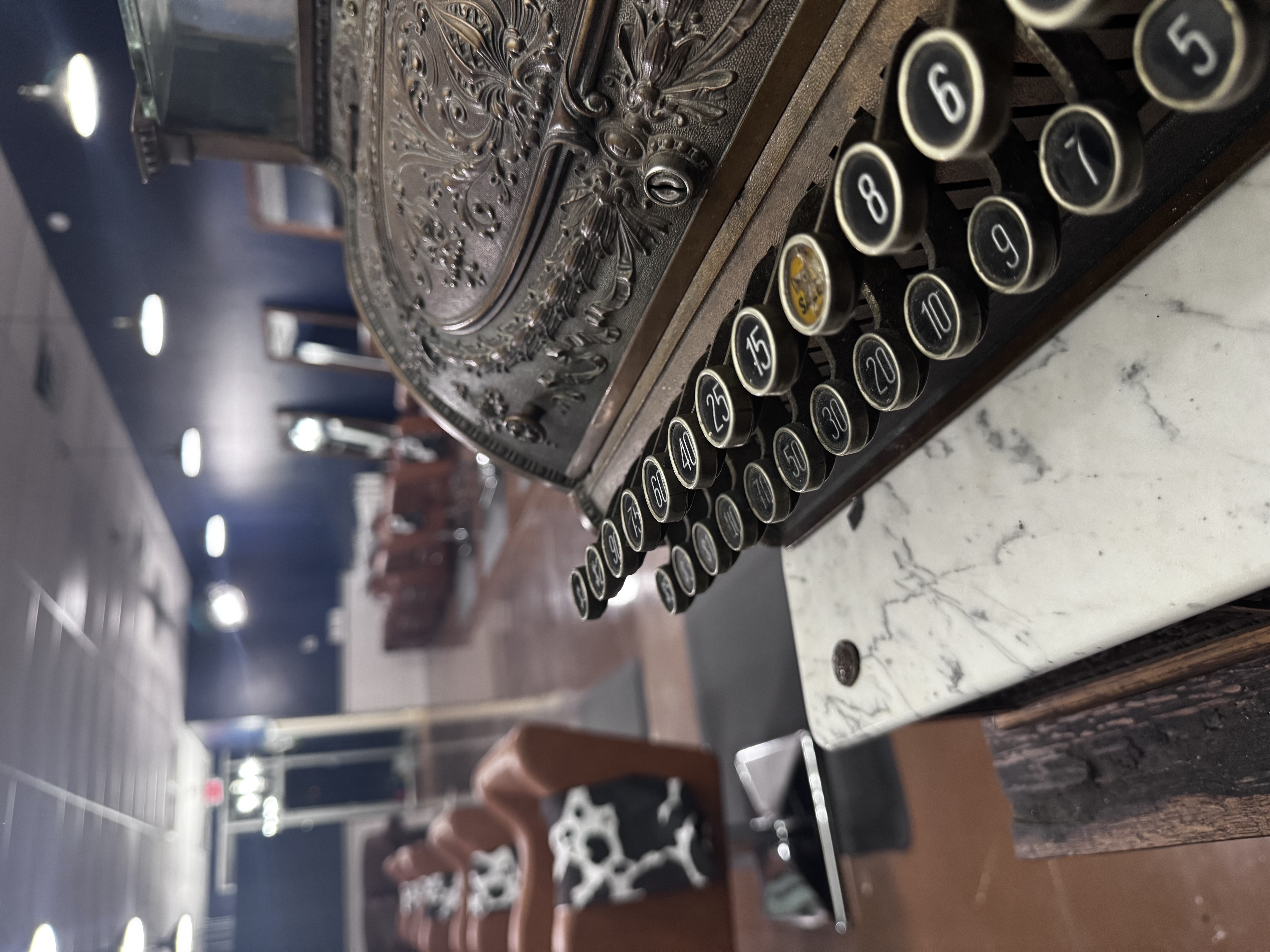 Vintage antique cash register adding character to the Pearls & Whiskey salon interior