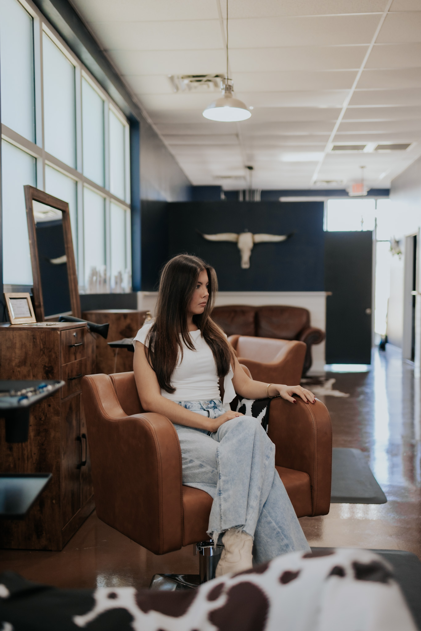 Salon guest relaxing in a styling chair at Pearls & Whiskey in Goose Creek, South Carolina