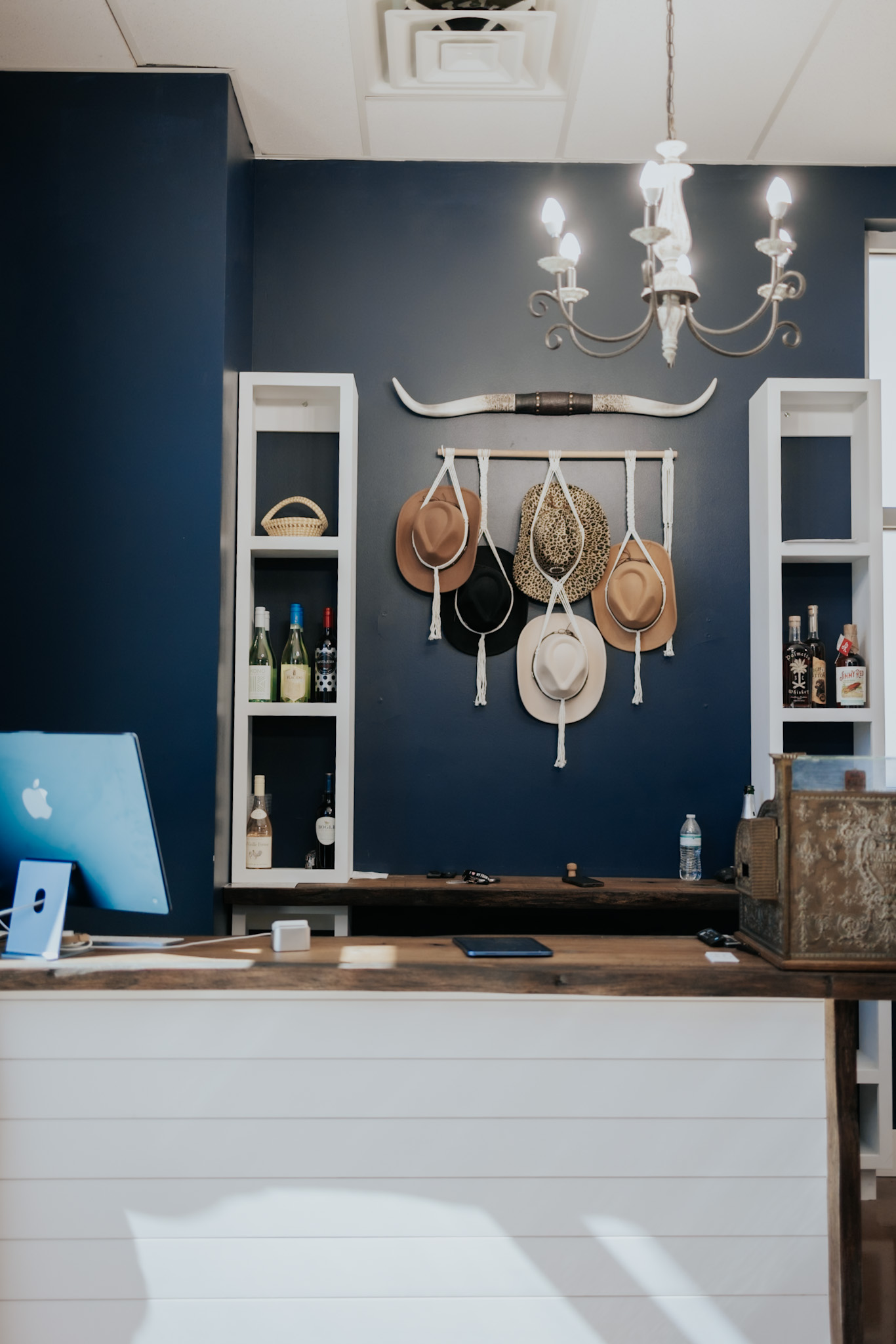 Western hat display and reception décor at Pearls & Whiskey salon in Goose Creek