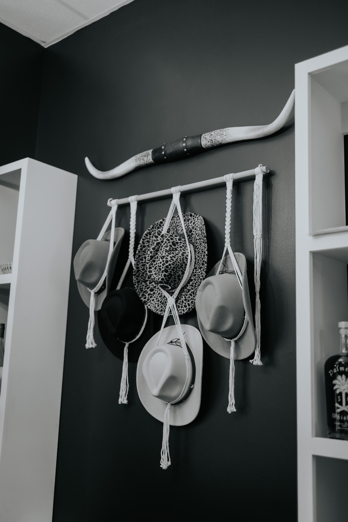 Black and white Western hat display inside Pearls & Whiskey salon in Goose Creek